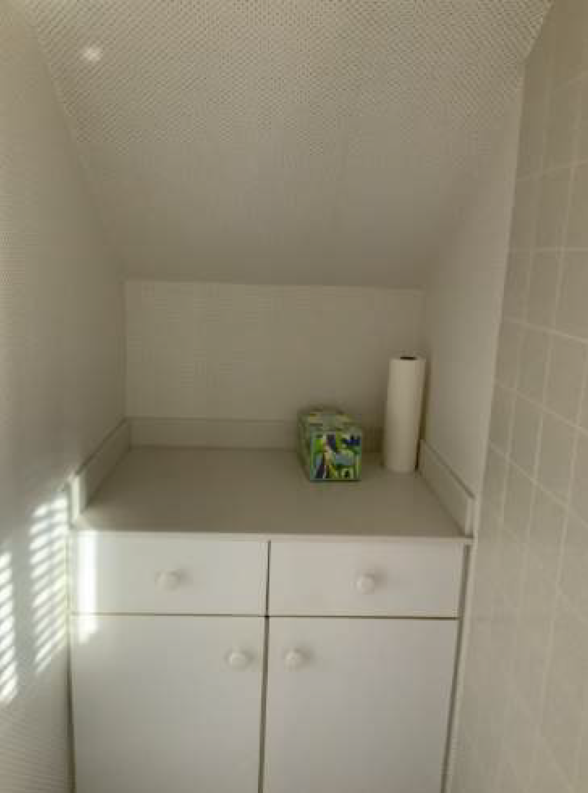 White cabinets with a countertop, tissue box, and paper towels in a small alcove.