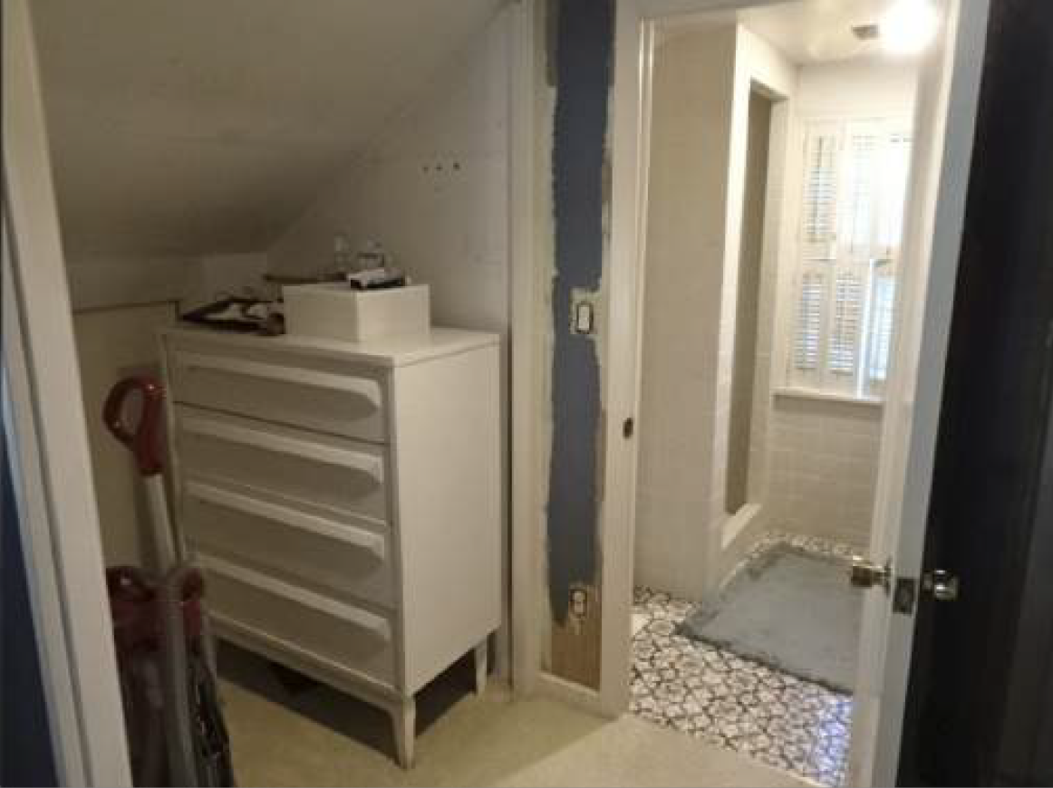 A white dresser and vacuum cleaner are in a small closet; a bathroom is visible through a doorway.