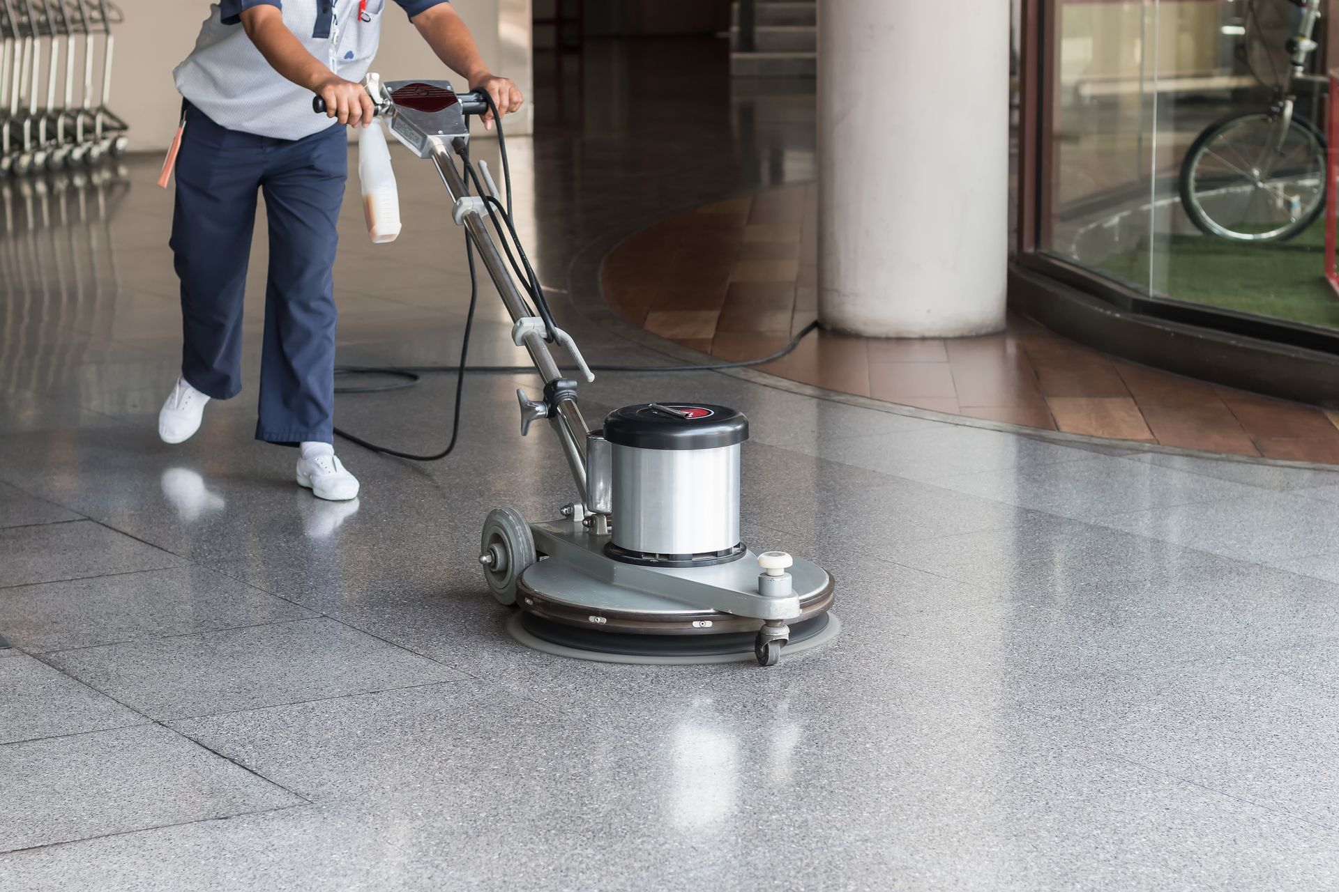 A man is using a machine to clean the floor of a building.