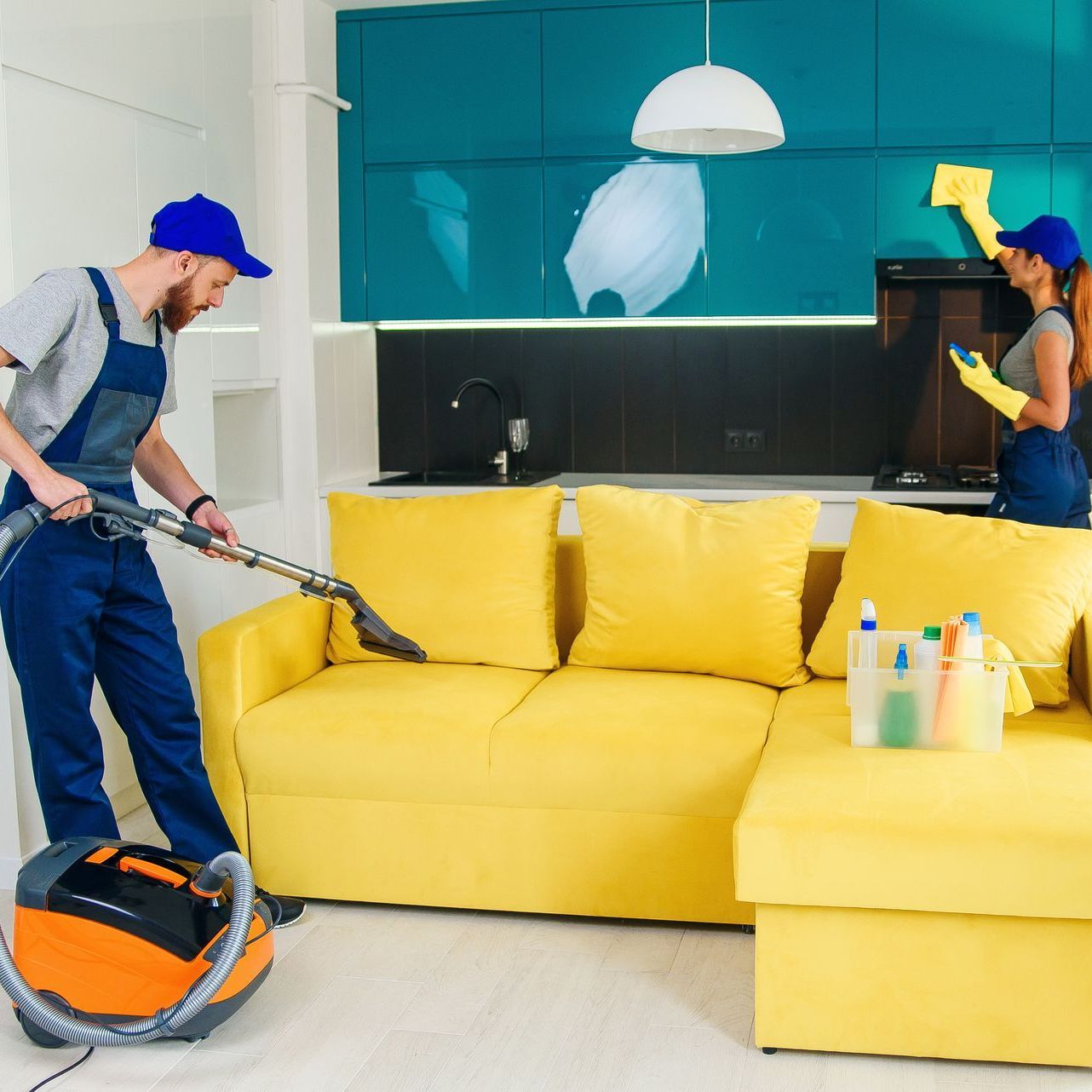 A man and a woman are cleaning a living room with a vacuum cleaner.
