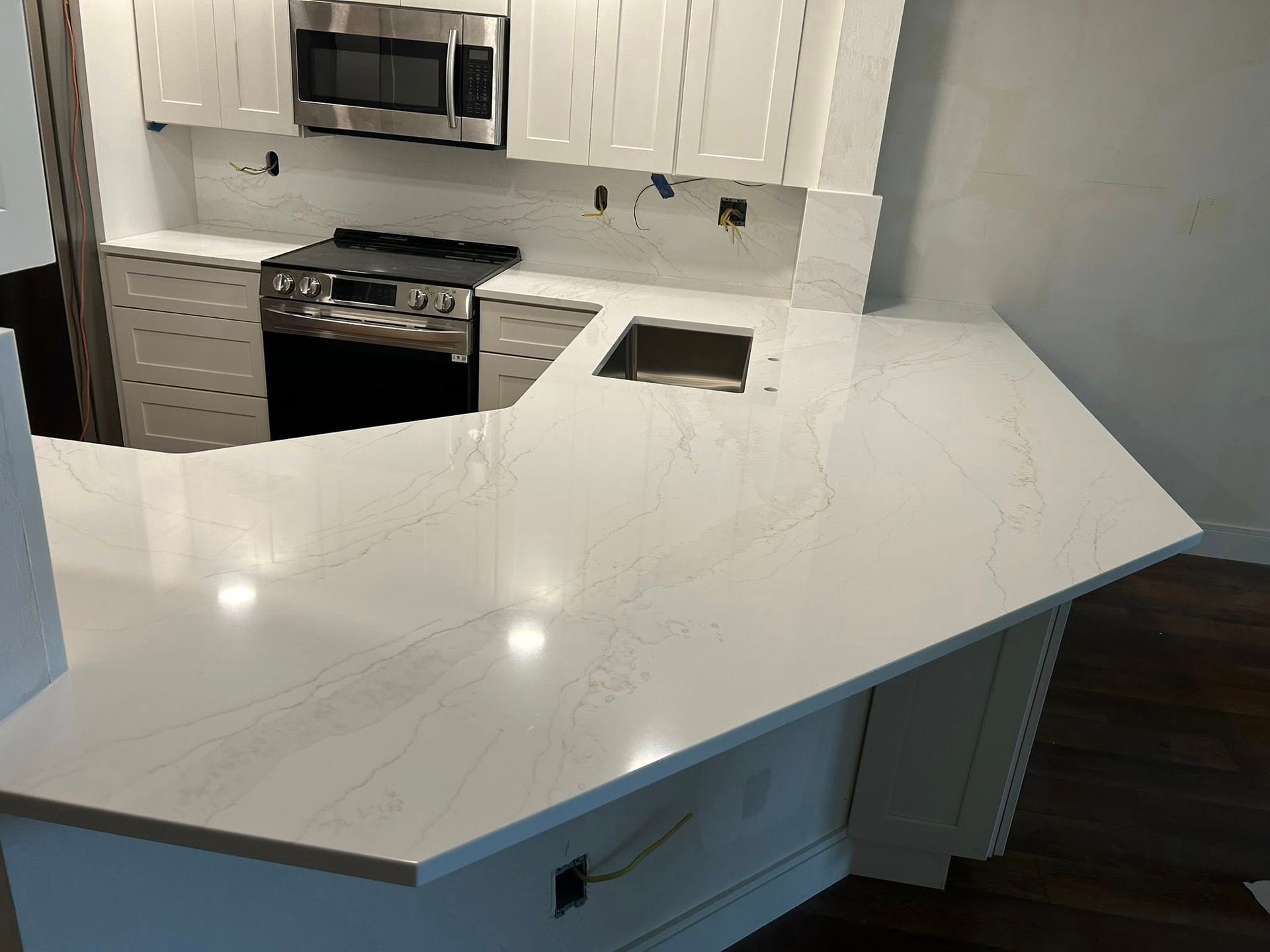 Modern kitchen with a large white quartz island and stainless steel appliances