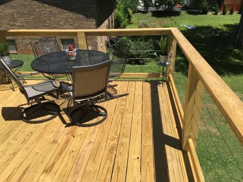 A wooden deck with a table and chairs on it.