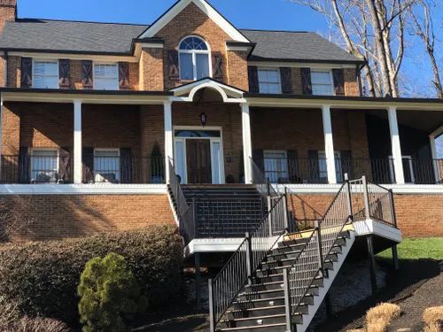 A large brick house with stairs leading up to the front door.