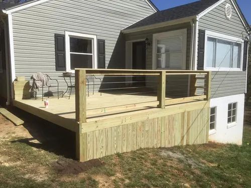 A house with a wooden deck in front of it.