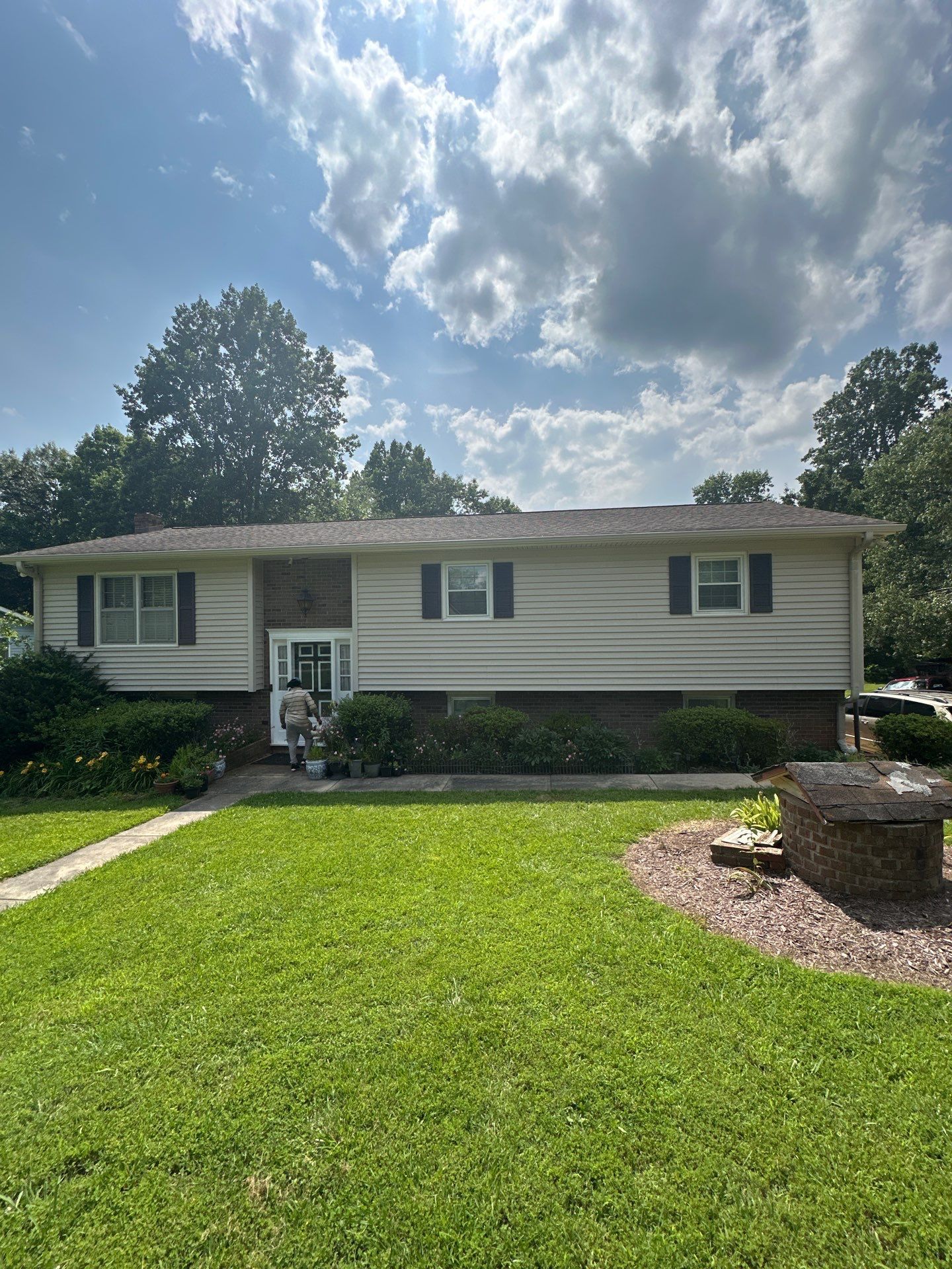A white house with a large lawn in front of it.