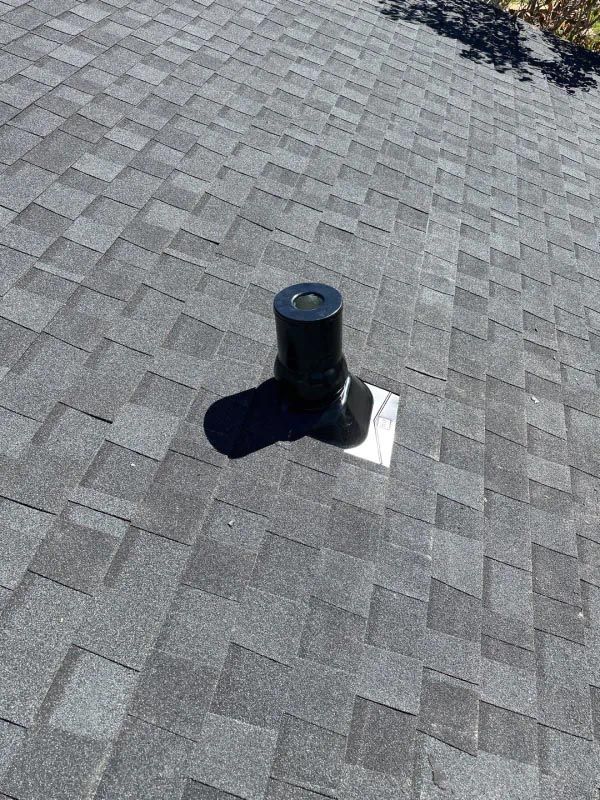 A black pipe is sitting on top of a roof.