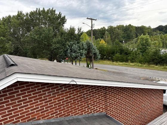 A brick building with a roof that is covered in shingles.
