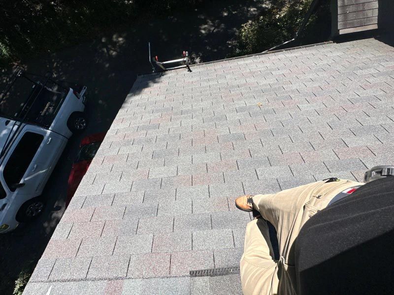 A man is sitting on the roof of a building.