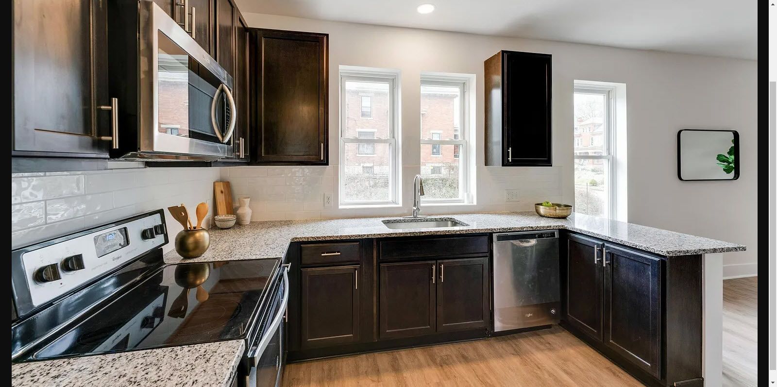Modern kitchen with dark cabinets, stainless steel appliances, and granite countertops.