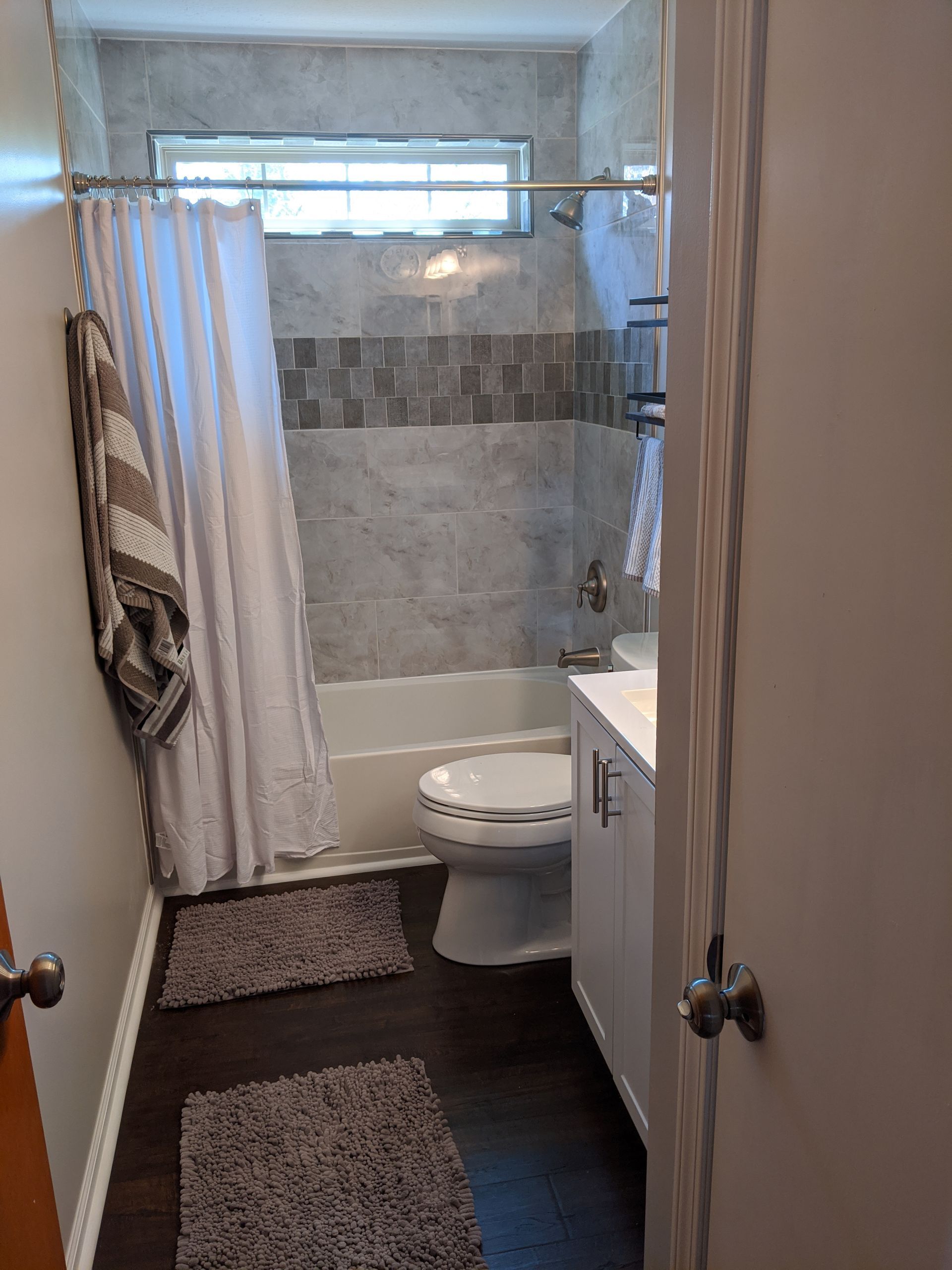 A bathroom with a toilet , sink , bathtub and shower curtain.