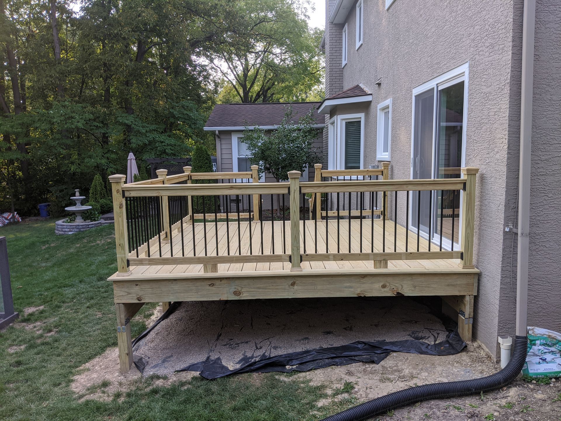 A wooden deck with a railing in front of a house.