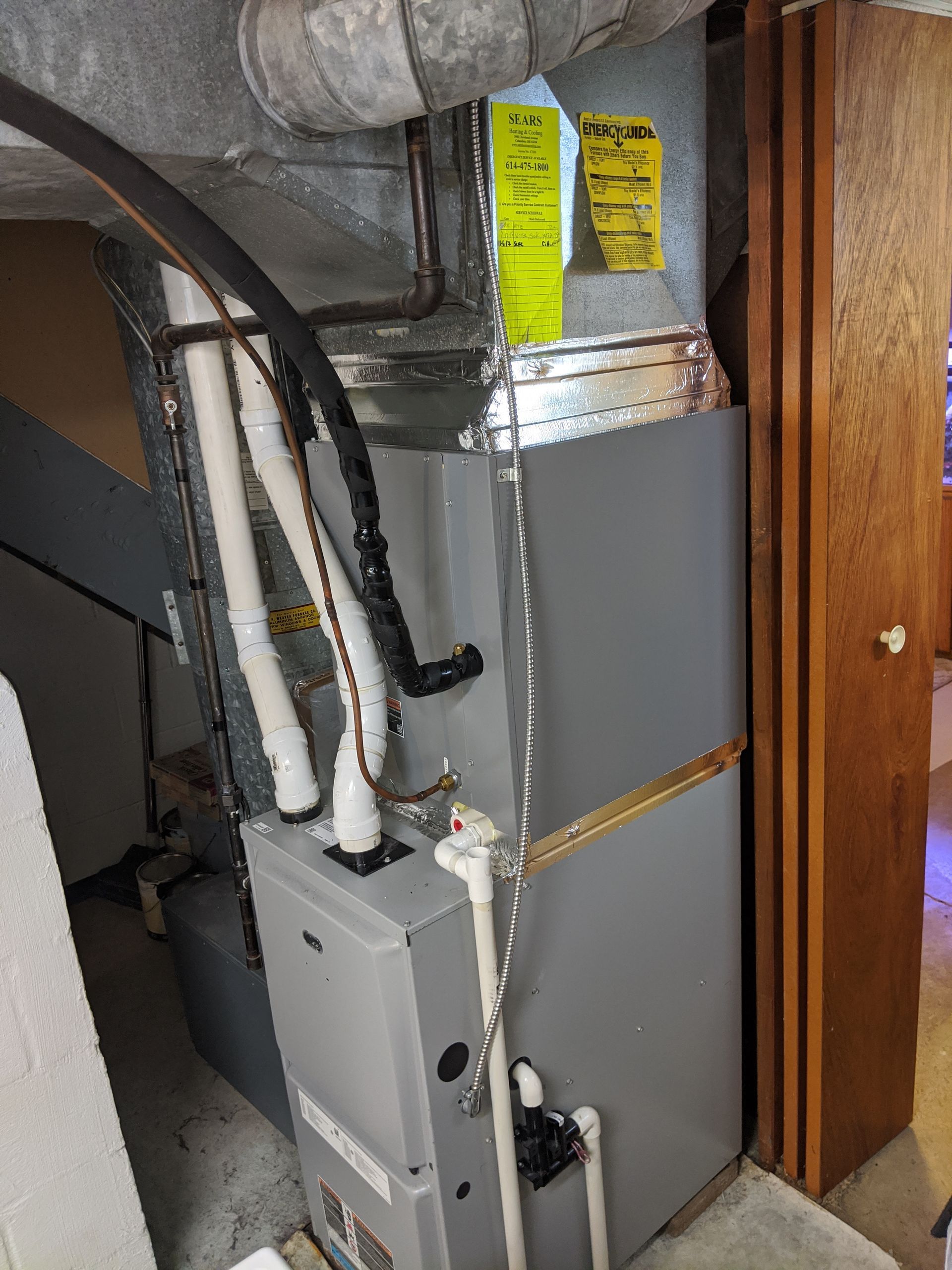 An air conditioner is sitting in a room next to a door.