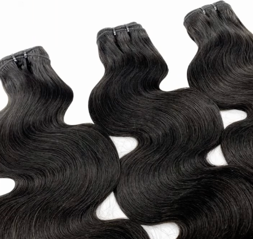 A woman is getting her hair extensions done by a hairdresser.