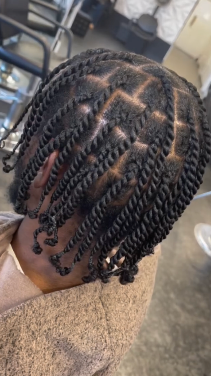 A close up of a person 's hair with braids in a salon.