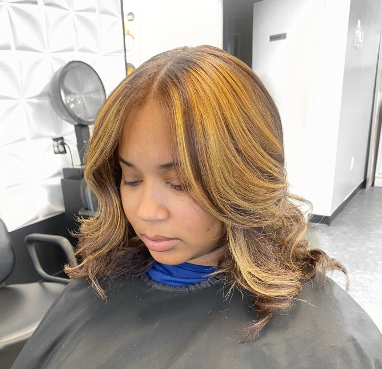 A woman is getting her hair cut in a salon.
