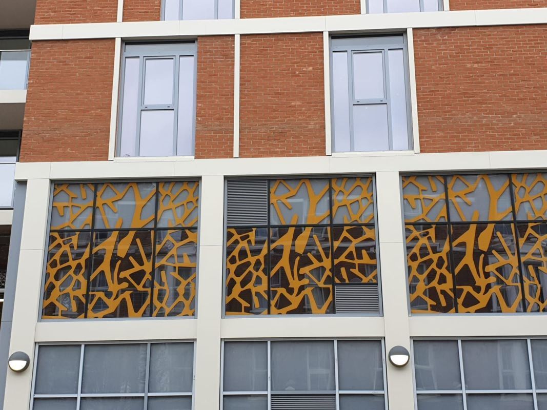 Brick building with decorative gold and brown panels below windows.