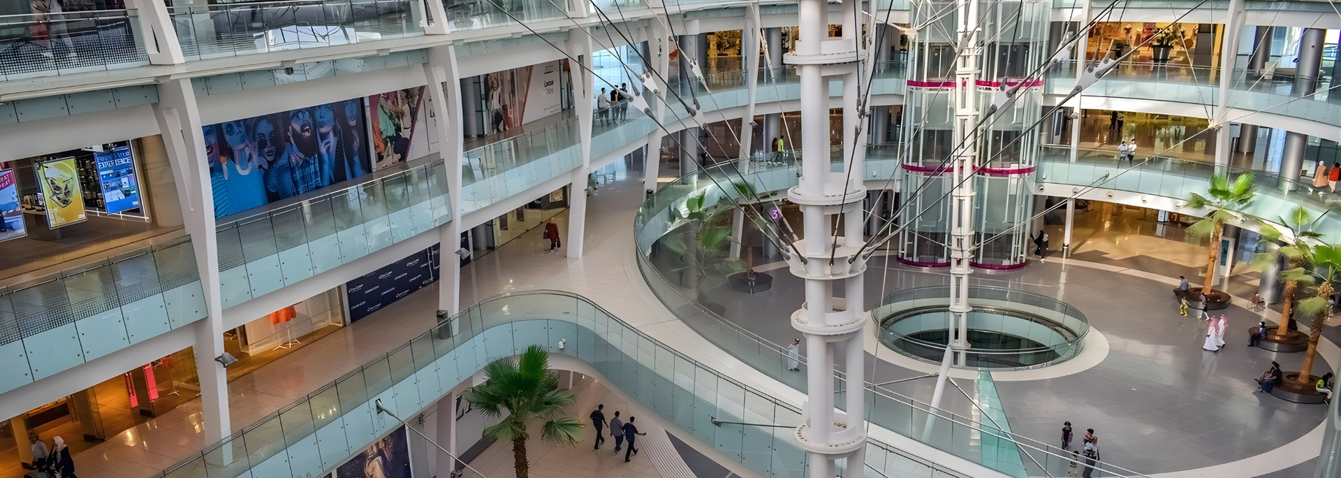 Interior view of a multistory shopping mall with shops and walkways around a central open space.