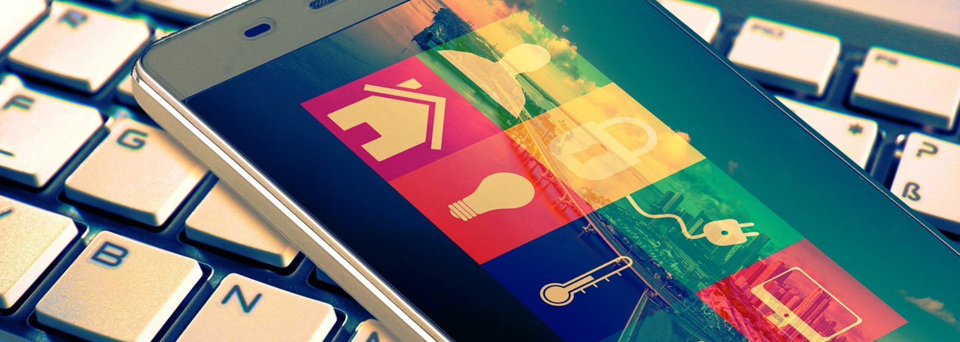 Smartphone displaying app icons on a keyboard.