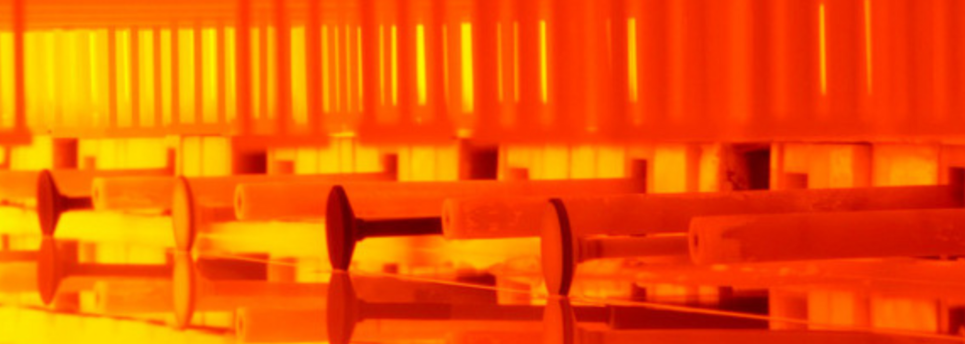 Rows of orange cylinders in an industrial setting.