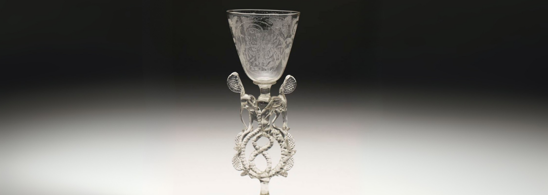 Ornate clear glass goblet on a gradient background.