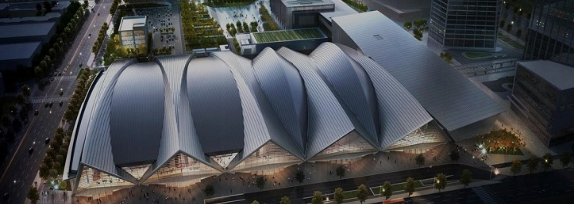 An aerial view of a modern building with a distinctive, curved roof design.
