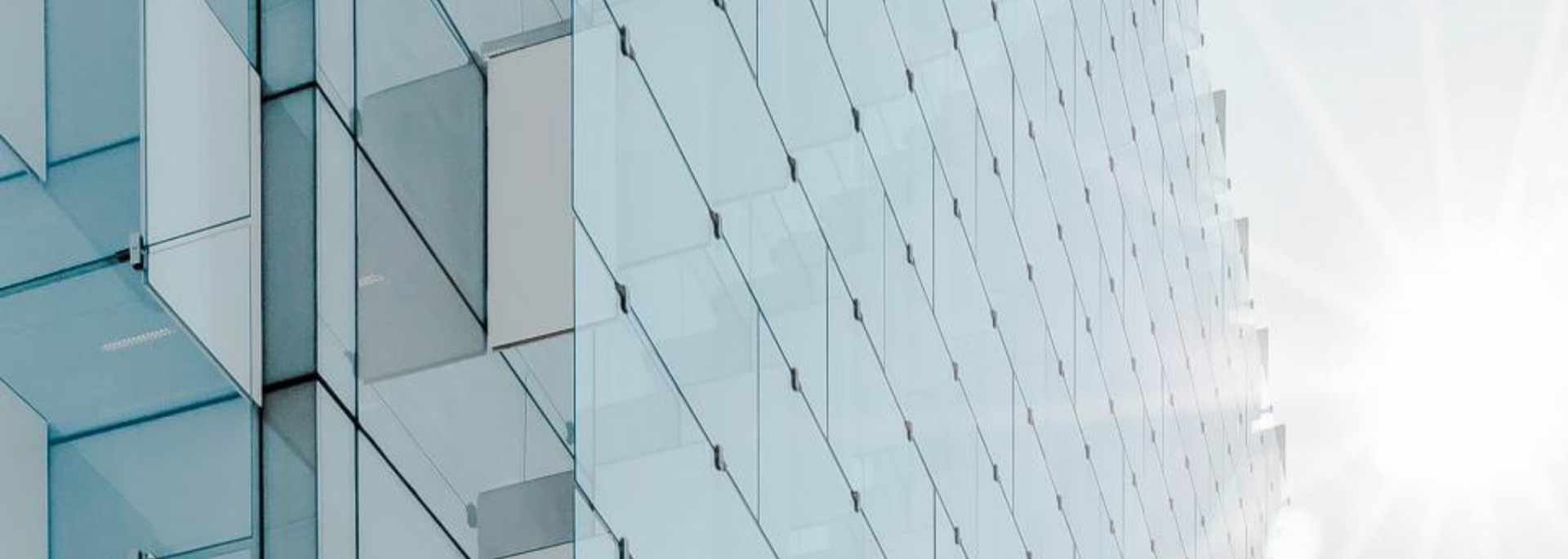 Modern glass building with a bright sky.