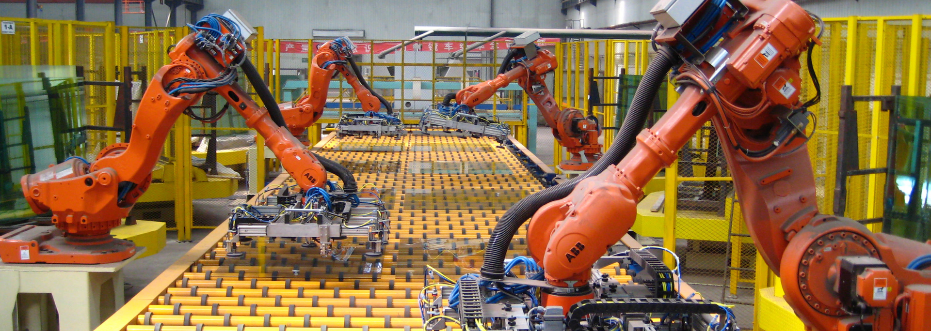 Robotic arms on an assembly line. Orange robots in a factory.
