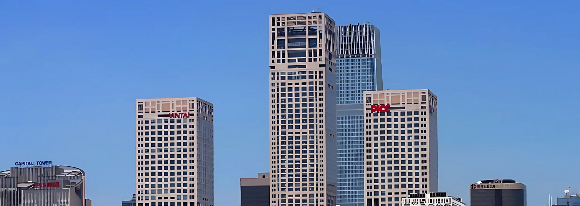 Tall, modern skyscrapers against a clear blue sky, likely in an urban setting.