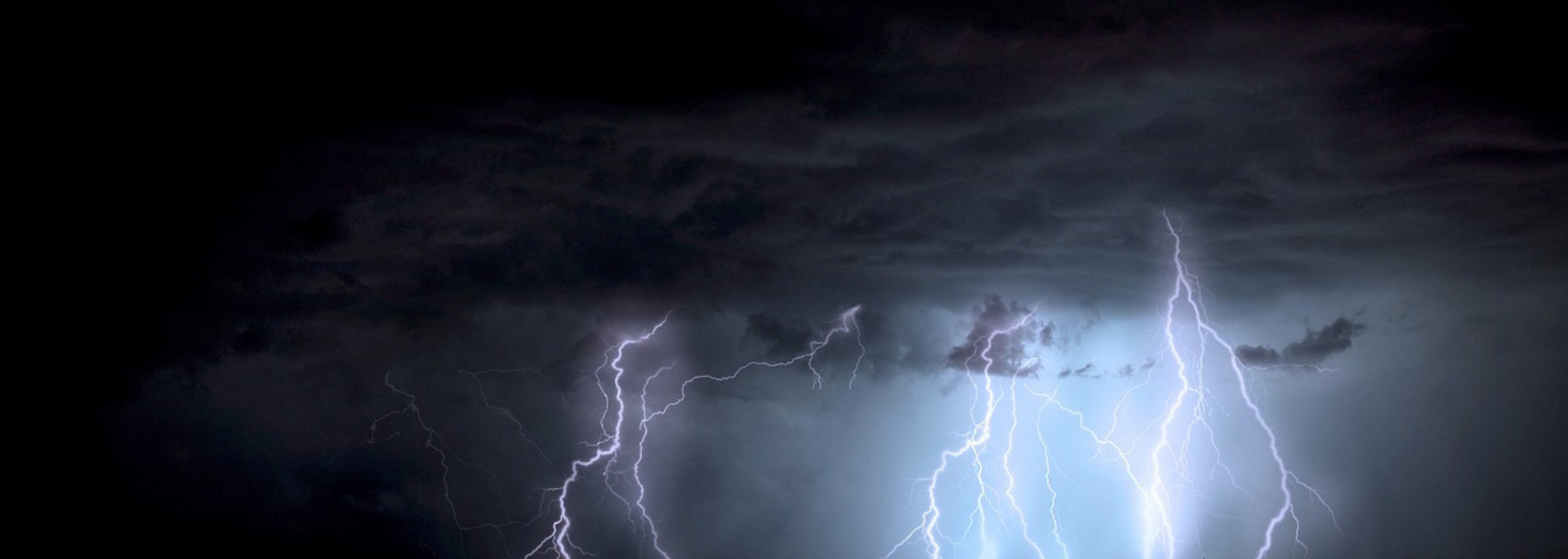 Lightning flashes across a dark, stormy sky.