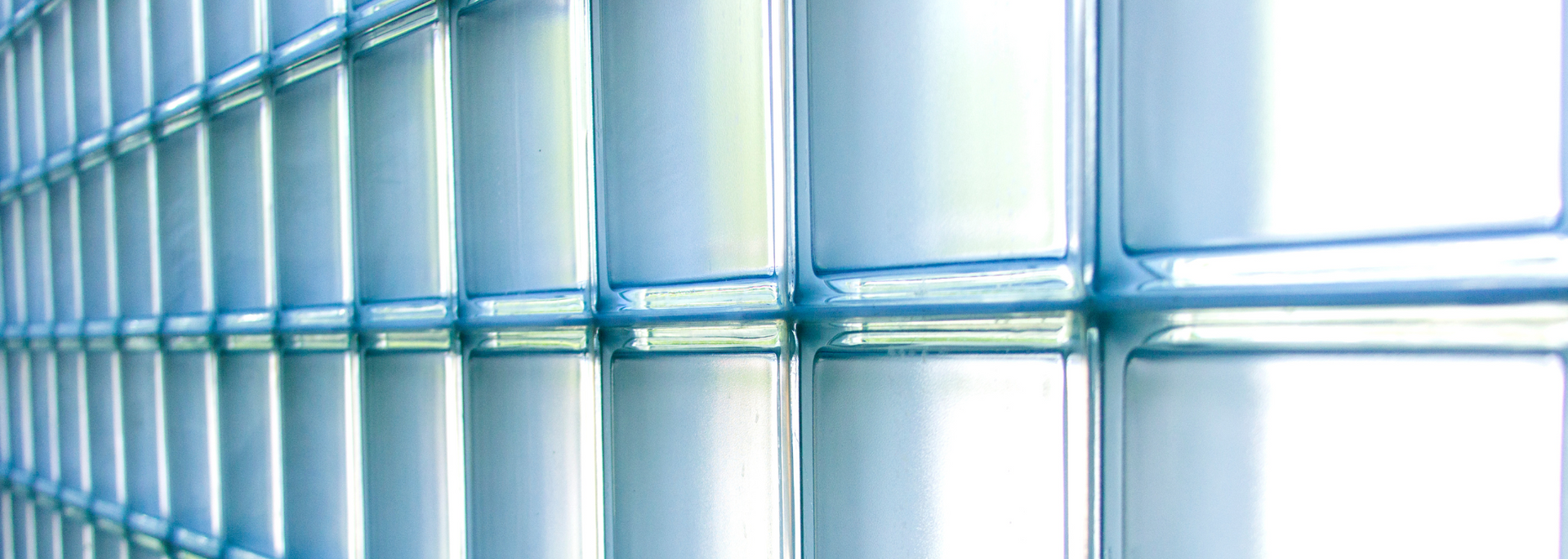 A close-up of a blue-toned metal grid fence. The grid creates many square openings.