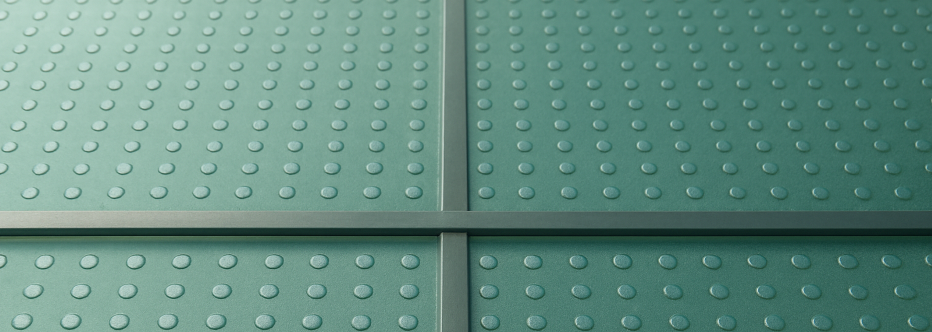 Green textured surface with raised dots and gray metal dividers.