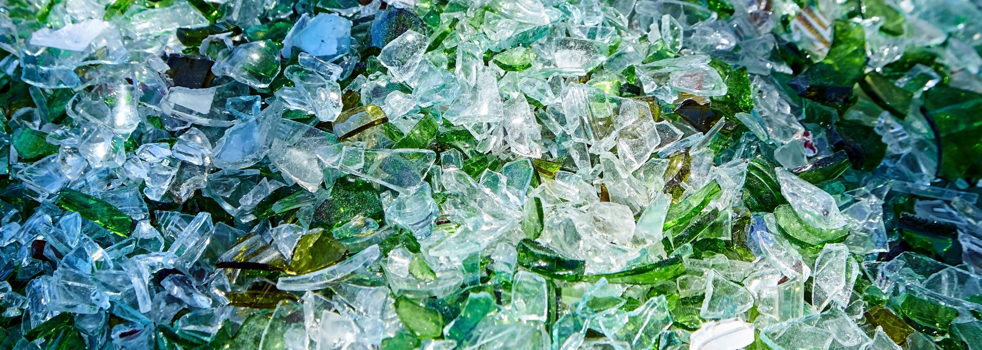 Close-up of broken glass pieces in shades of blue and green.