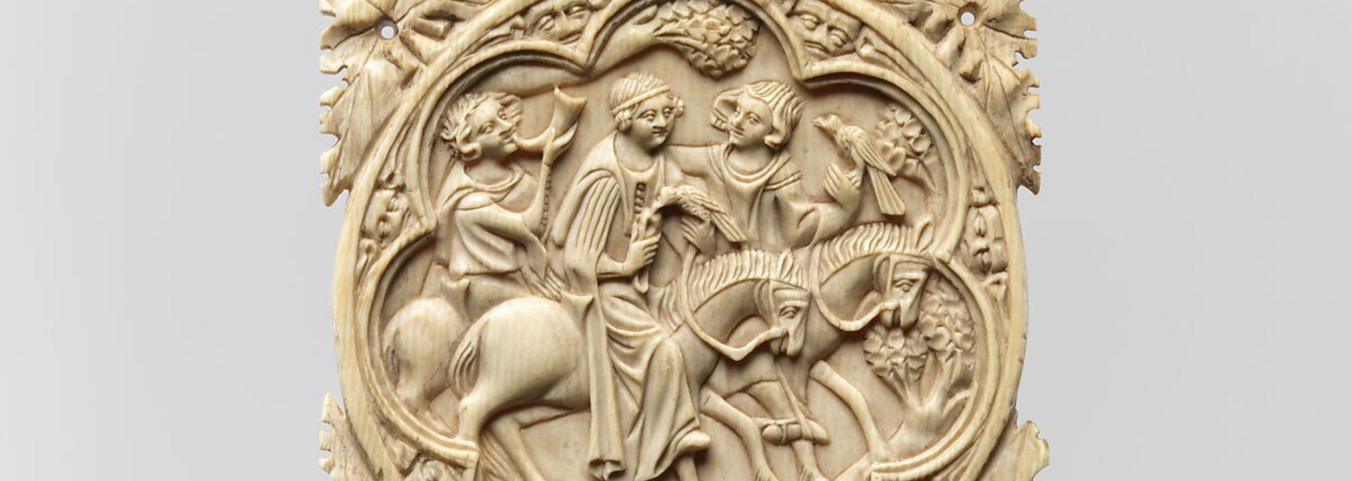 Ivory relief carving of two figures on horses meeting two other figures.