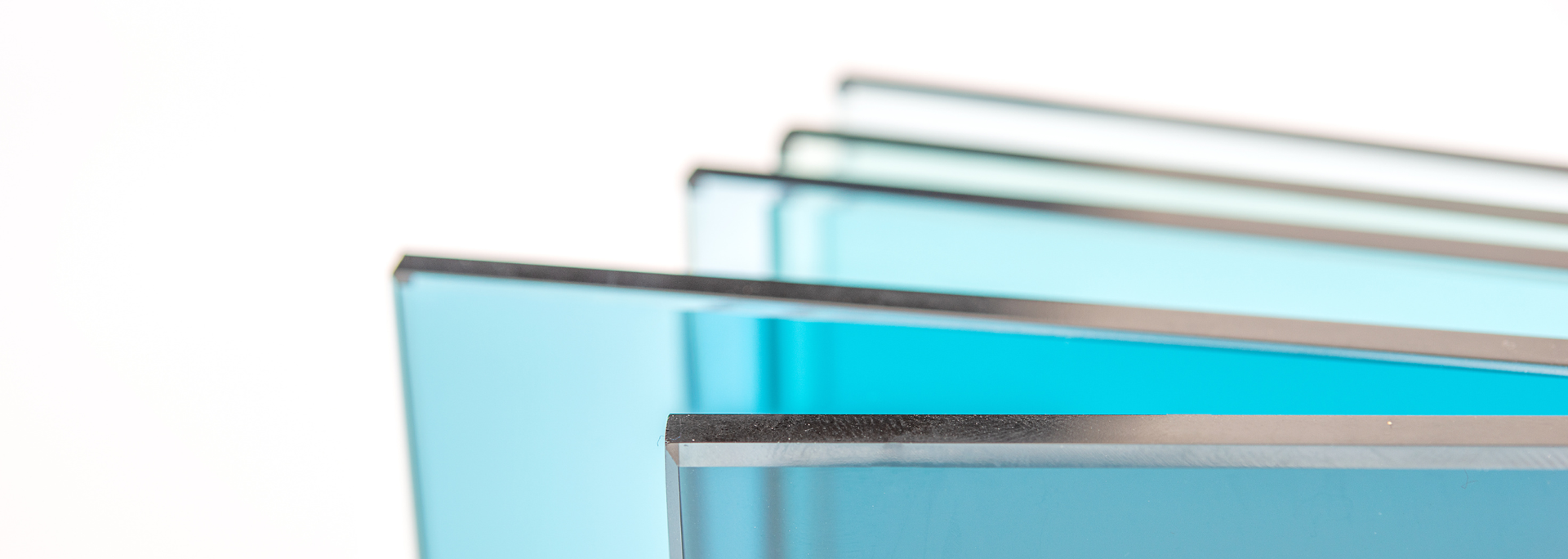 Stack of colorful glass sheets, varying shades of blue, on a white background.