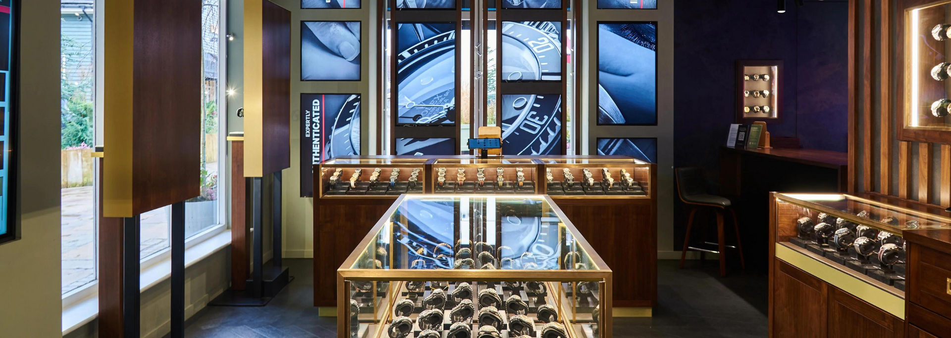 A watch store interior with display cases, wood paneling, and a central display case.