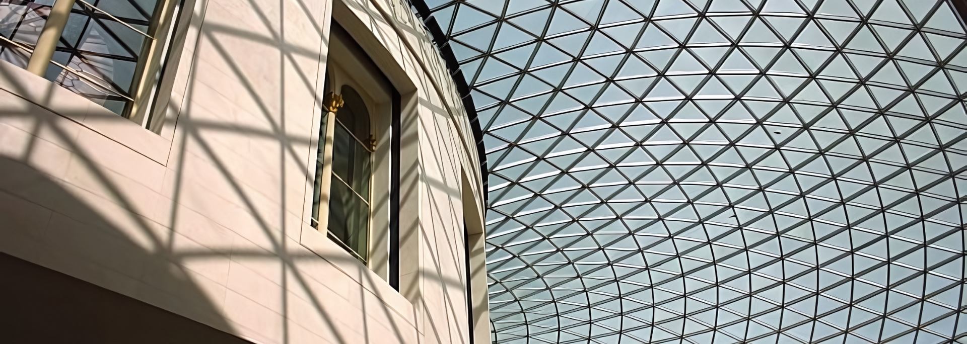 Interior of a building with a glass triangular patterned ceiling and a window.