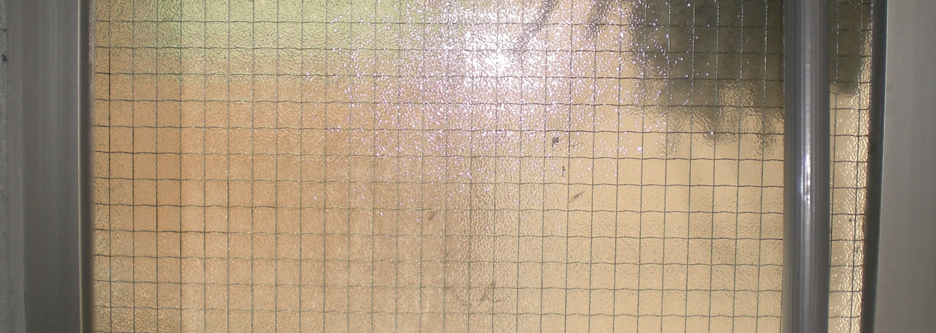 Frosted glass panel with grid pattern, in a light-colored frame.