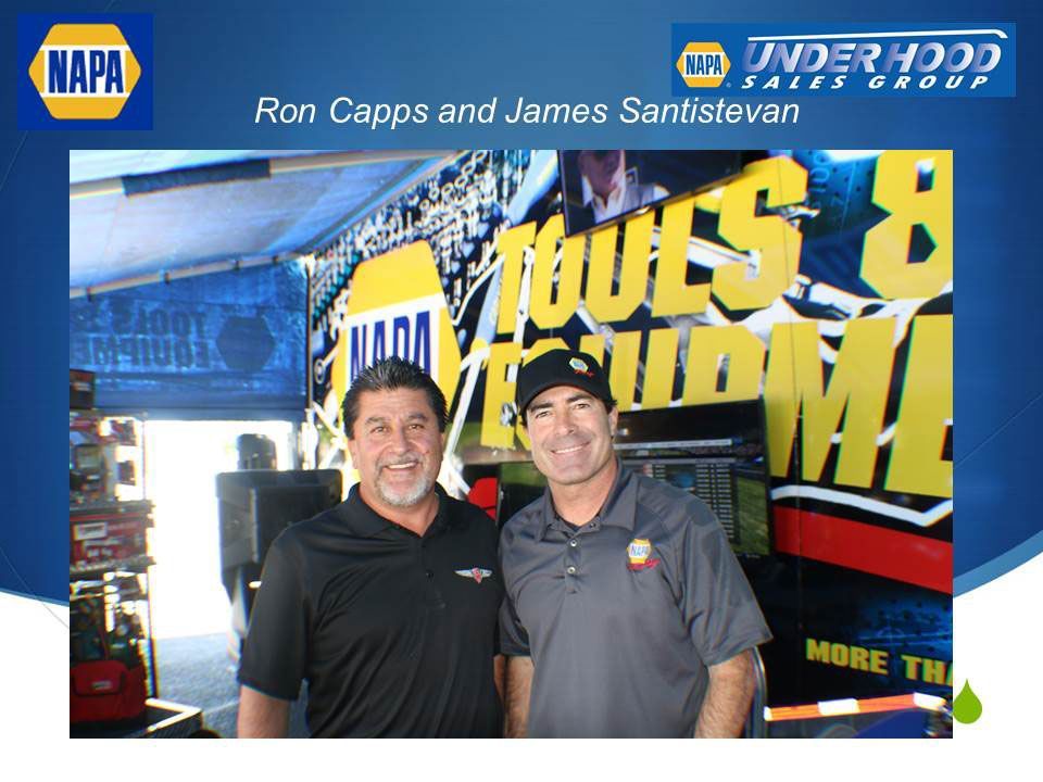 Two men are posing for a picture in front of a napa sign | Zia Automotive