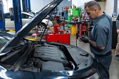 Technician looking in hood of car | Zia Automotive