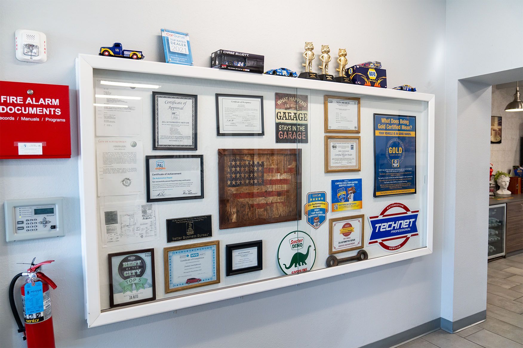 A wall with a lot of plaques and trophies on it. | Zia Automotive