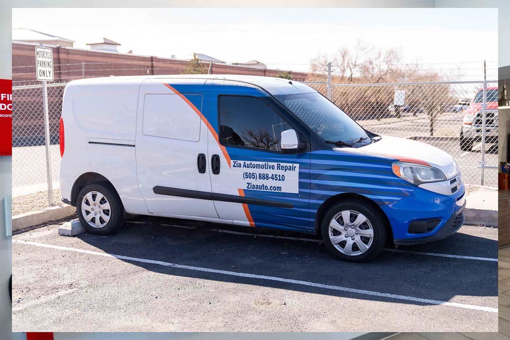 A white and blue van is parked in a parking lot | Zia Automotive