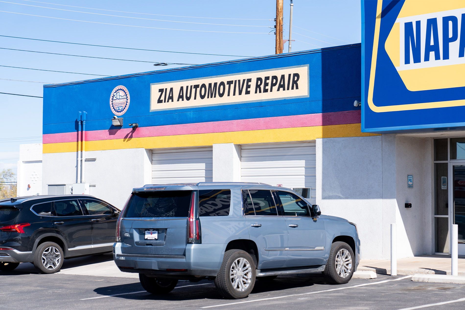 Two cars are parked in front of a napa automotive repair shop. | Zia Automotive