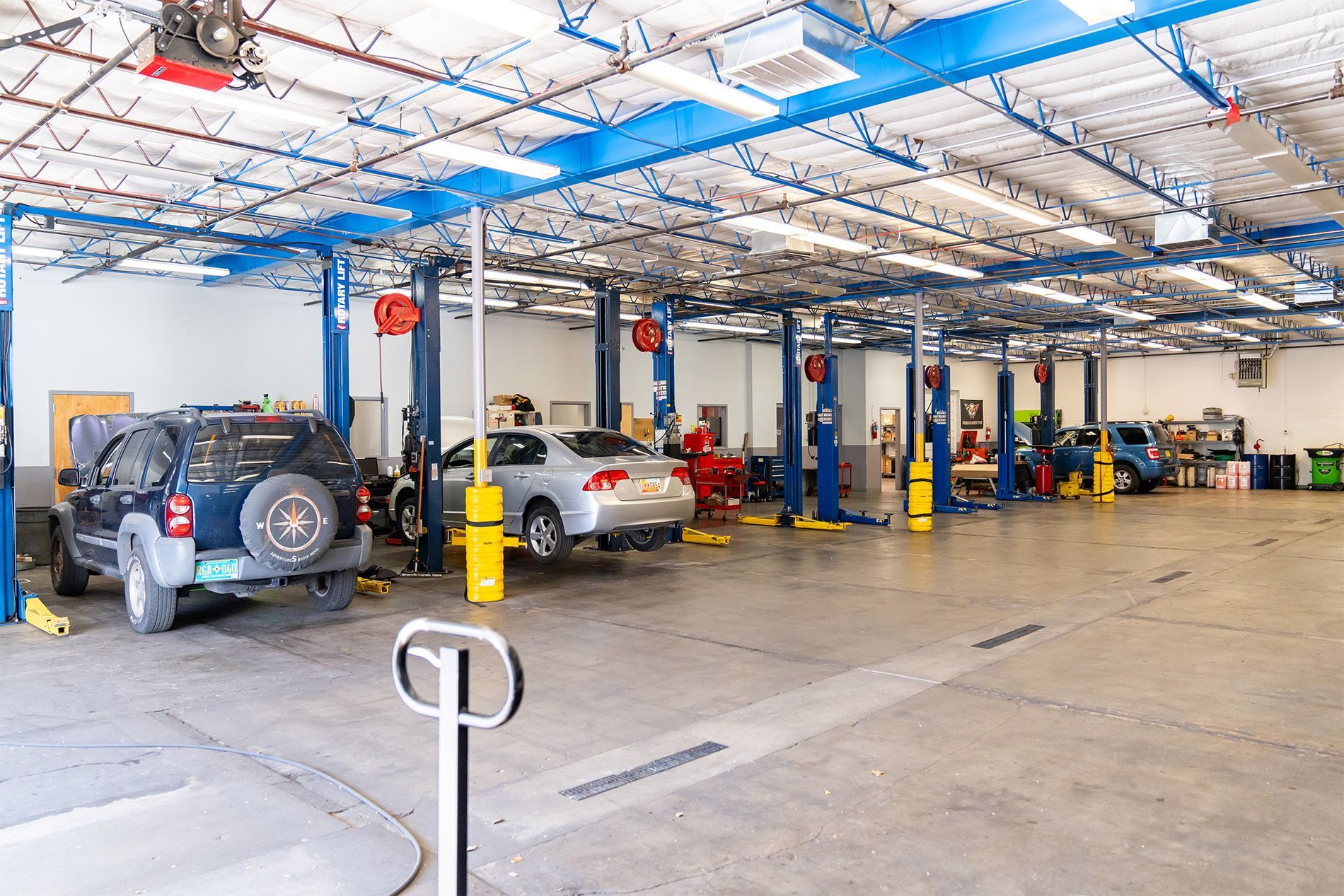 A lot of cars are being worked on in a garage. | Zia Automotive