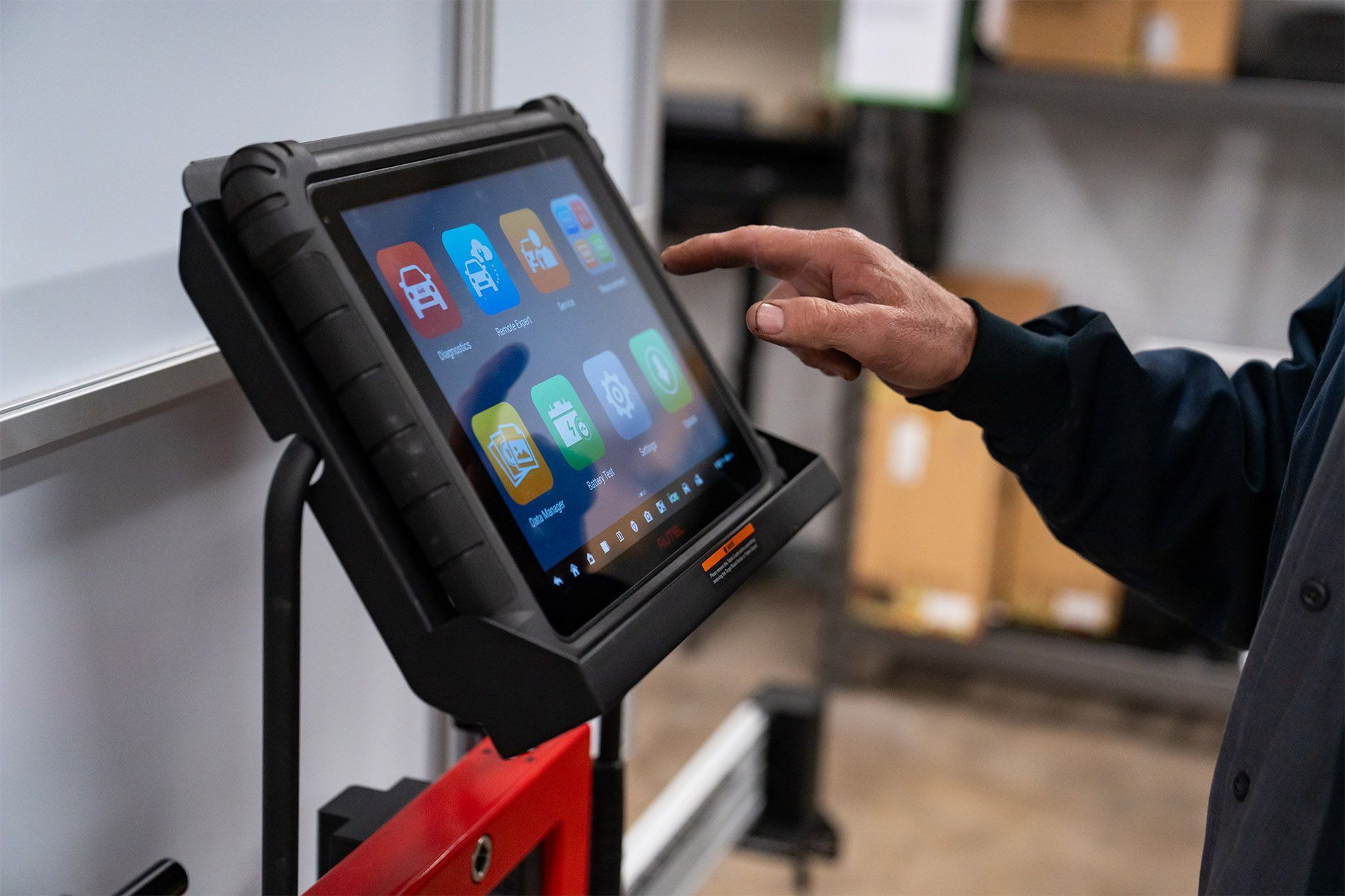 A man is using a tablet computer in a warehouse. | Zia Automotive