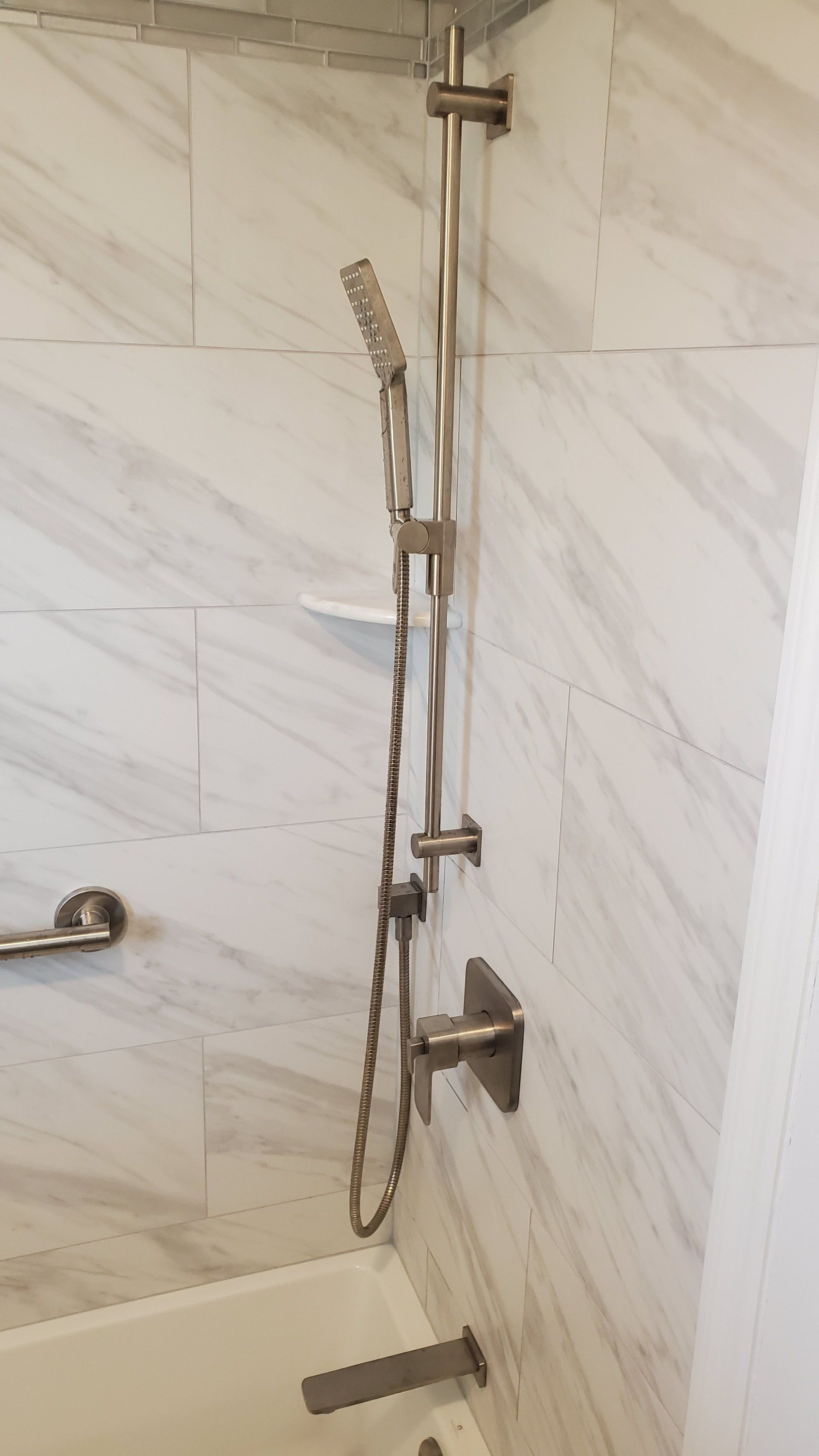 A bathroom with a shower head and a bathtub.