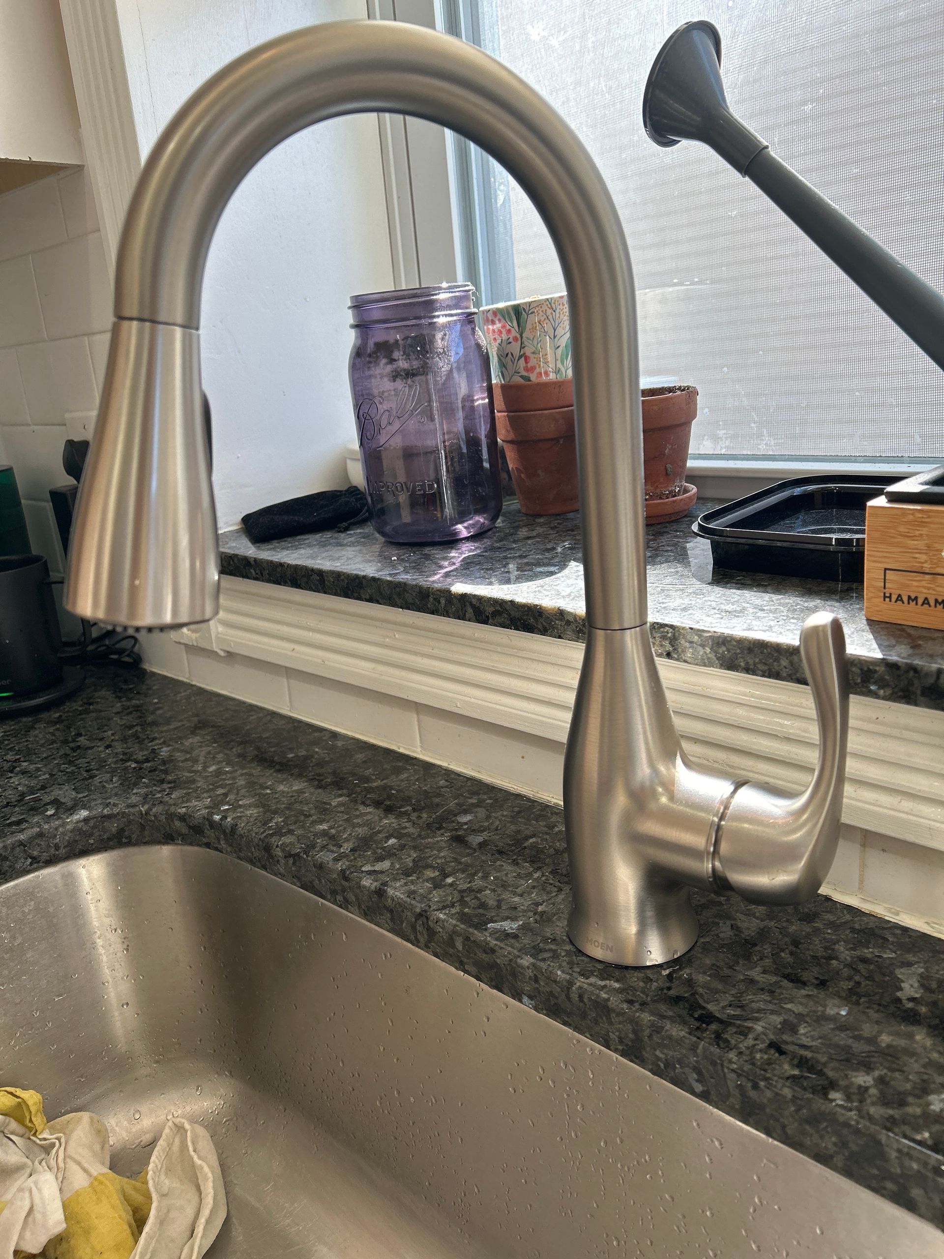 A stainless steel kitchen sink with a faucet on the counter.