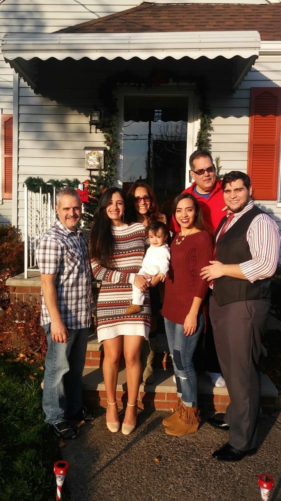 A group of people are posing for a picture in front of a house.