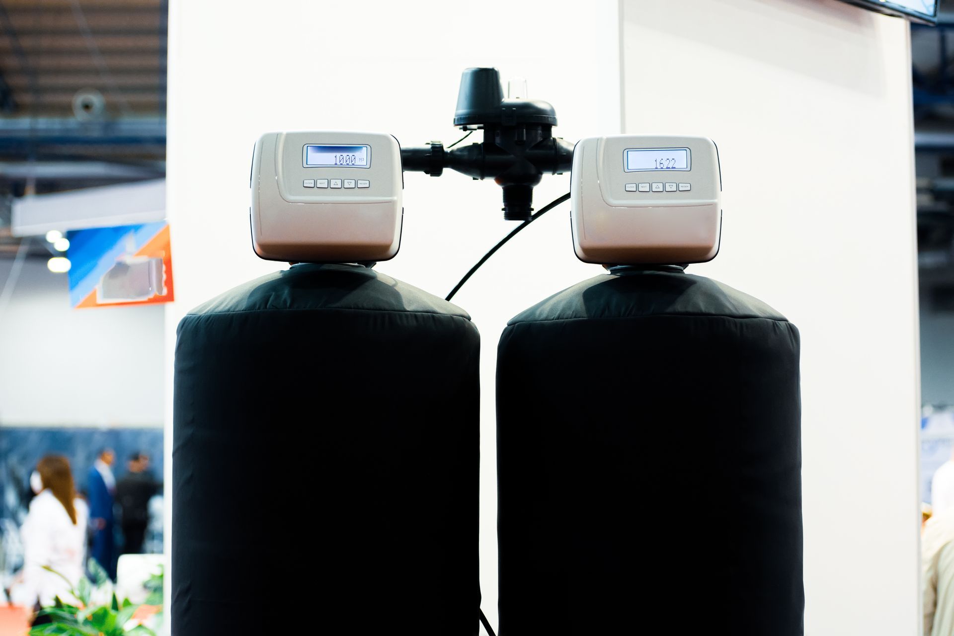 Two black water filters are sitting next to each other in a room.