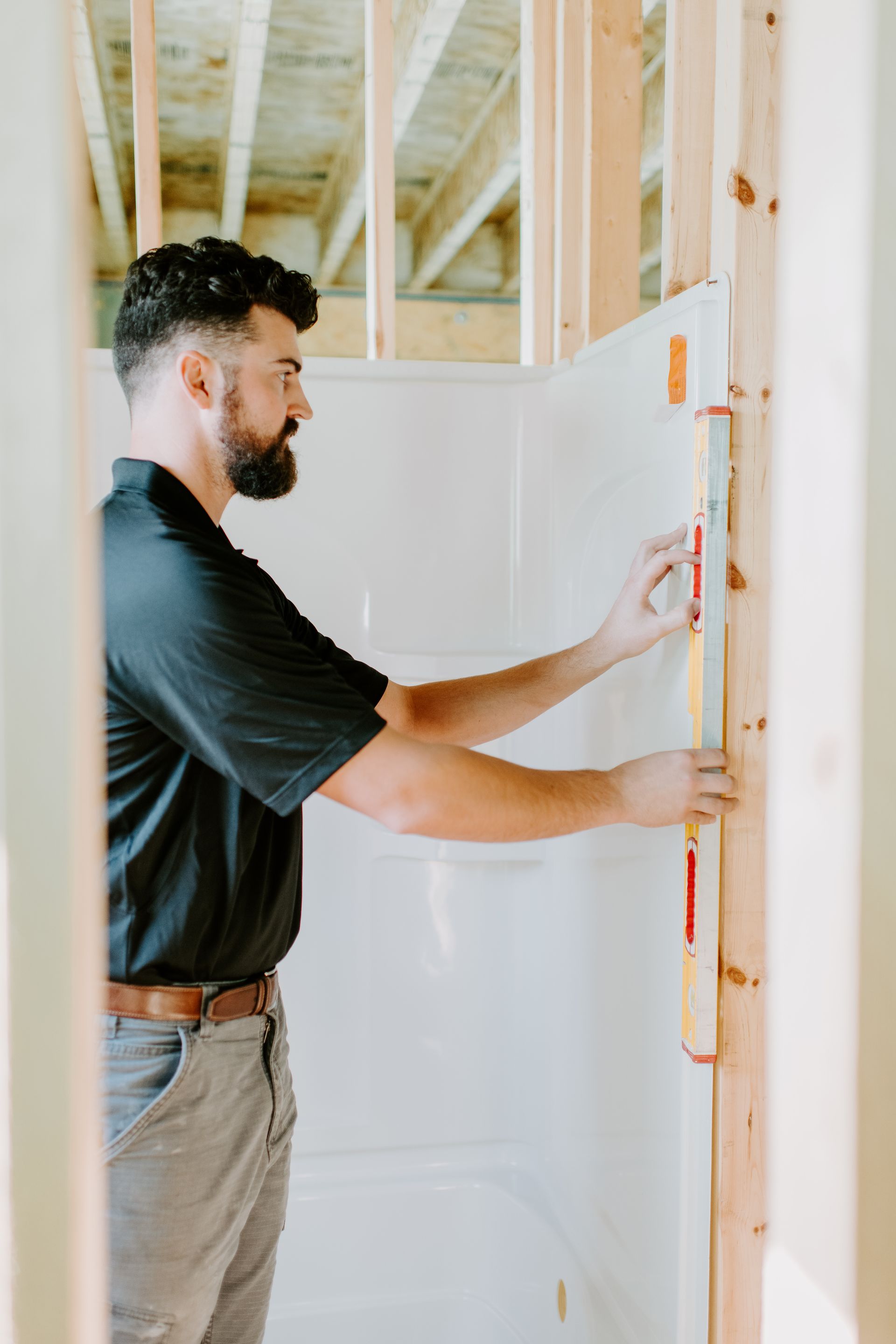 A man is measuring a wall with a tape measure.