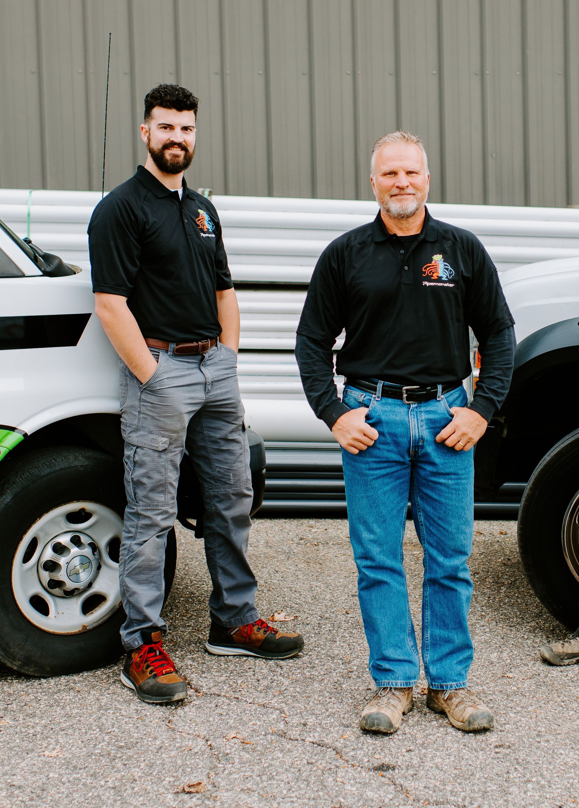 Two men are standing next to each other in front of a truck.